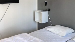 A hotel room with a bed, a bedside table, a wall-mounted TV, and a power outlet. - 4 Star Holiday Home in Salen (Salen)