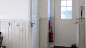 A hallway with a white door, a window, and a red fire extinguisher mounted on the wall. - 4 Star Holiday Home in Salen (Salen)