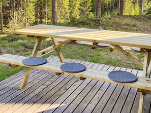 Een houten picknicktafel met bankjes op een terras.