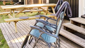 A wooden deck with a folding chair and a table. - 4 Star Holiday Home in Salen (Salen)