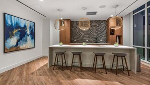A modern kitchen with a central island, pendant lights, and a large abstract painting on the wall. - Luxury 1BR in Downtown | Full Kitchen | W&D (White Plains)