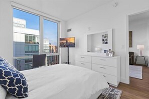 Relax in a spacious room with a large bed, flat-screen TV, and city view.