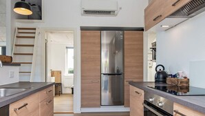 Une cuisine moderne avec des meubles en bois, des appareils électroménagers en acier inoxydable et un four encastré.