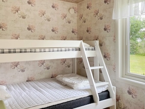 A bunk bed with a ladder, white bedding, and a window with a view of greenery. - 4 Person Holiday Home in Hogklint (Visby)
