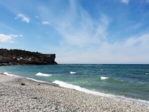 A pebble beach with a rocky cliff and ocean view. - 4 Person Holiday Home in Hogklint (Visby)