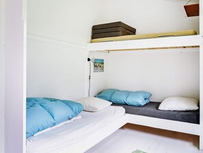 Habitación con literas, dos camas con ropa de cama azul y blanca.
