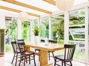 Enjoy meals in this dining area with a table and chairs, surrounded by a view of lush greenery.