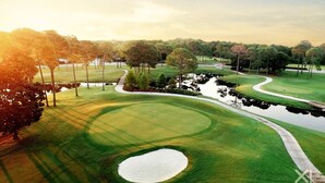 A golf course with a water hazard, trees, and a clear sky. - Pet-Friendly Beach Blessing Steps from the Gulf (Miramar Beach)