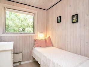 A bedroom with a single bed, a bedside table, a window, and two wall-mounted picture frames. - 5 Person Holiday Home in Tranekaer (Tranekaer)