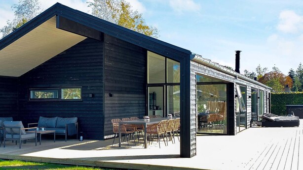 A modern house with a deck, outdoor seating, and large windows. - 12 Person Holiday Home in Vaeggerlose (Vaeggerlose)