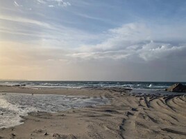 Una playa con huellas visibles y olas.