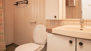 Une salle de bain avec des toilettes, un lavabo et un miroir au-dessus du lavabo.