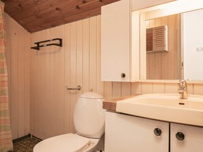 A bathroom with a toilet, a sink, and a mirror above the sink.