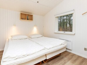 A bedroom with a bed, two wall-mounted lights, a window with a view of trees, and a wooden shelf above the bed. - 6 Person Holiday Home in Fjerritslev (Fjerritslev)