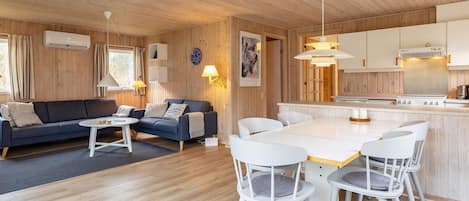 A cozy cabin interior with a living area, dining space, and kitchen.