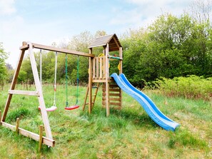 A wooden playground with a slide and swings. - 6 Person Holiday Home in Fjerritslev (Fjerritslev)