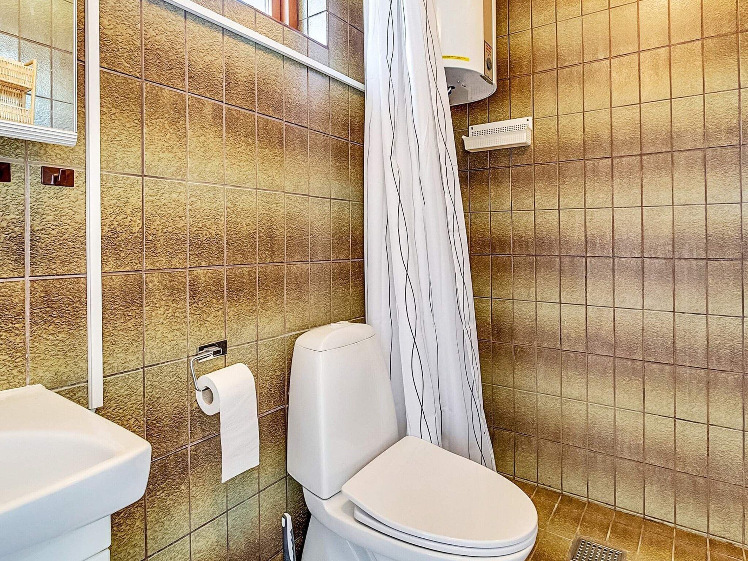 A bathroom with a toilet, a sink, and a shower curtain.