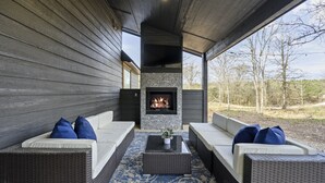 An outdoor seating area with wicker furniture and a stone fireplace. - Family Fun! Private suites, garden games, fire pit & kids loft!  (Broken Bow)