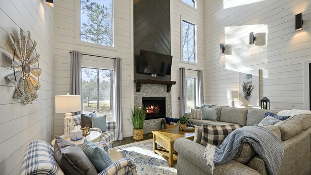 A spacious living room with a fireplace, large windows, and a cozy seating area. - Family Fun! Private suites, garden games, fire pit & kids loft!  (Broken Bow)