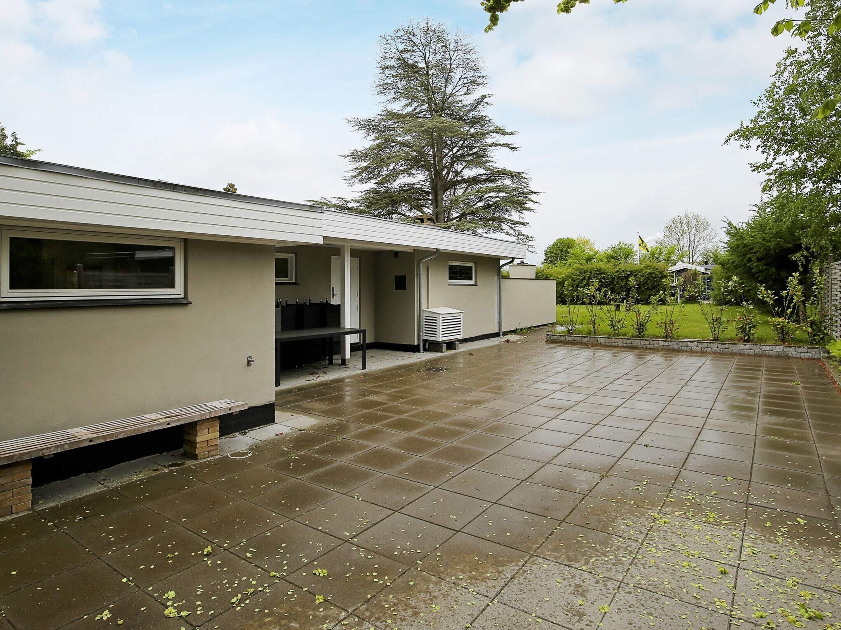 A building with a covered patio area, a bench, and a small table.