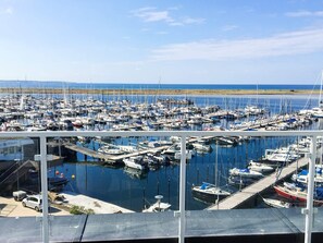 A marina with numerous boats docked in calm waters, a clear sky, and a distant shoreline. - 5 Star Holiday Home in Wendtorf (Wendtorf)