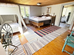 A room with a bunk bed, a wooden floor, a striped rug, and a bicycle. - 4 Person Holiday Home in Furuby (Hovmantorp)