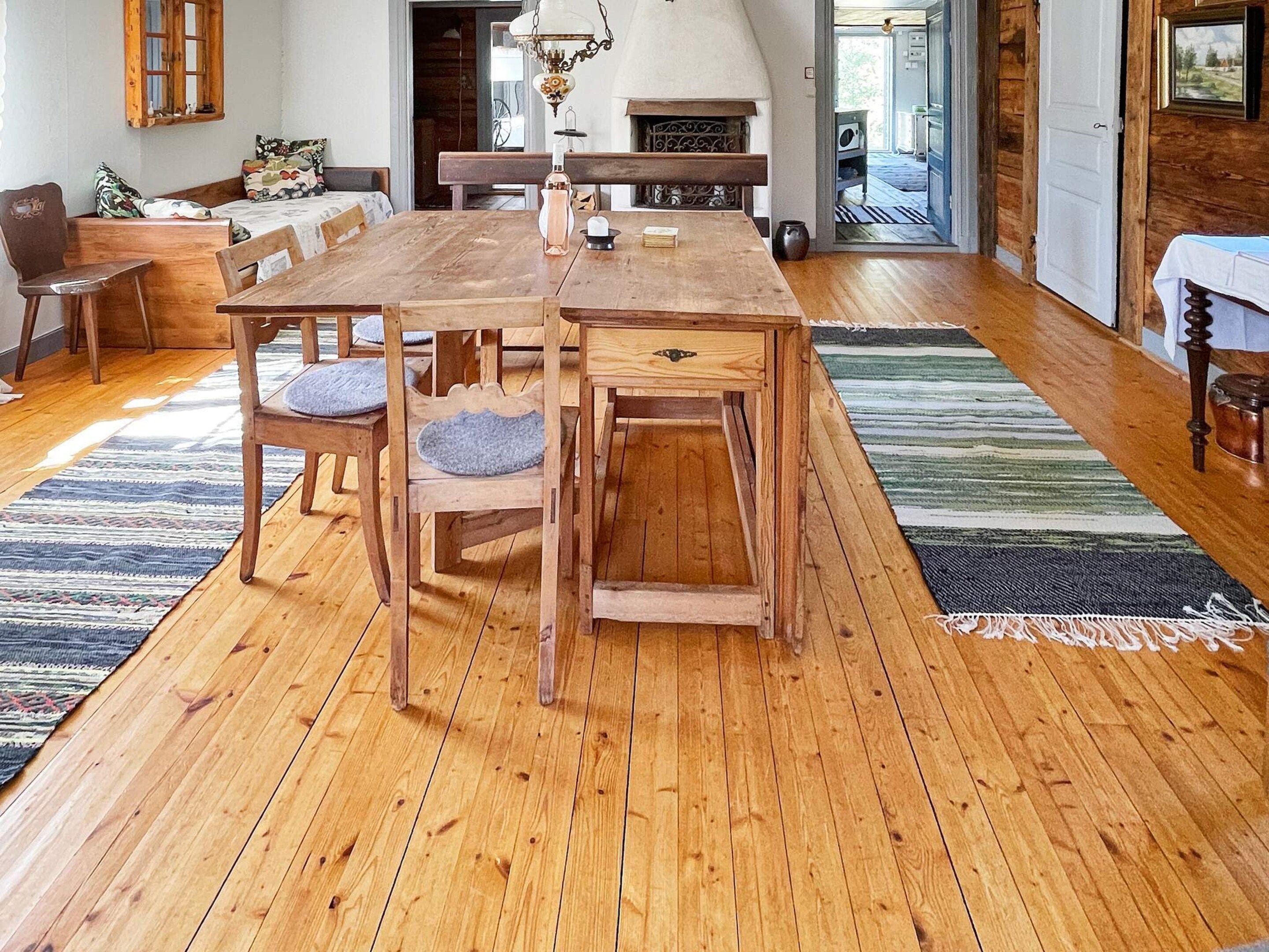 A wooden dining table with chairs, a fireplace, and a view of the outdoors.