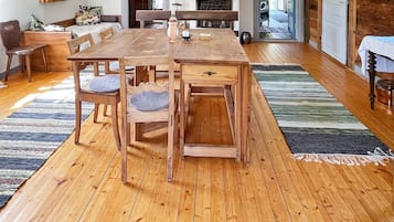 A wooden dining table with chairs, a fireplace, and a view of the outdoors.