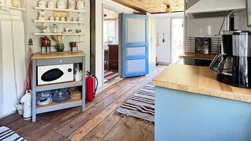 A kitchen with wooden flooring, a coffee maker, and a fire extinguisher.