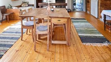 A wooden dining table with chairs, a fireplace, and a view of the outdoors.