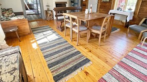 A cozy living room with a wooden dining table, chairs, and a fireplace. - 4 Person Holiday Home in Furuby (Hovmantorp)