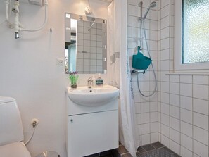 A bathroom with a white sink, mirror, and shower.