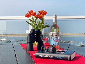 A table with a book, a bottle, glasses, and binoculars.