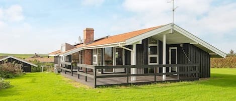 A modern house with a large deck and a sloped roof.