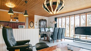 A modern kitchen with wooden cabinets, a microwave, and pendant lighting. - 6 Person Holiday Home in Laeso (Læsø)