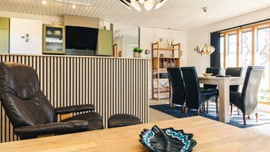 A modern dining area with a wooden table, black leather chairs, and a decorative bowl. - 6 Person Holiday Home in Laeso (Læsø)
