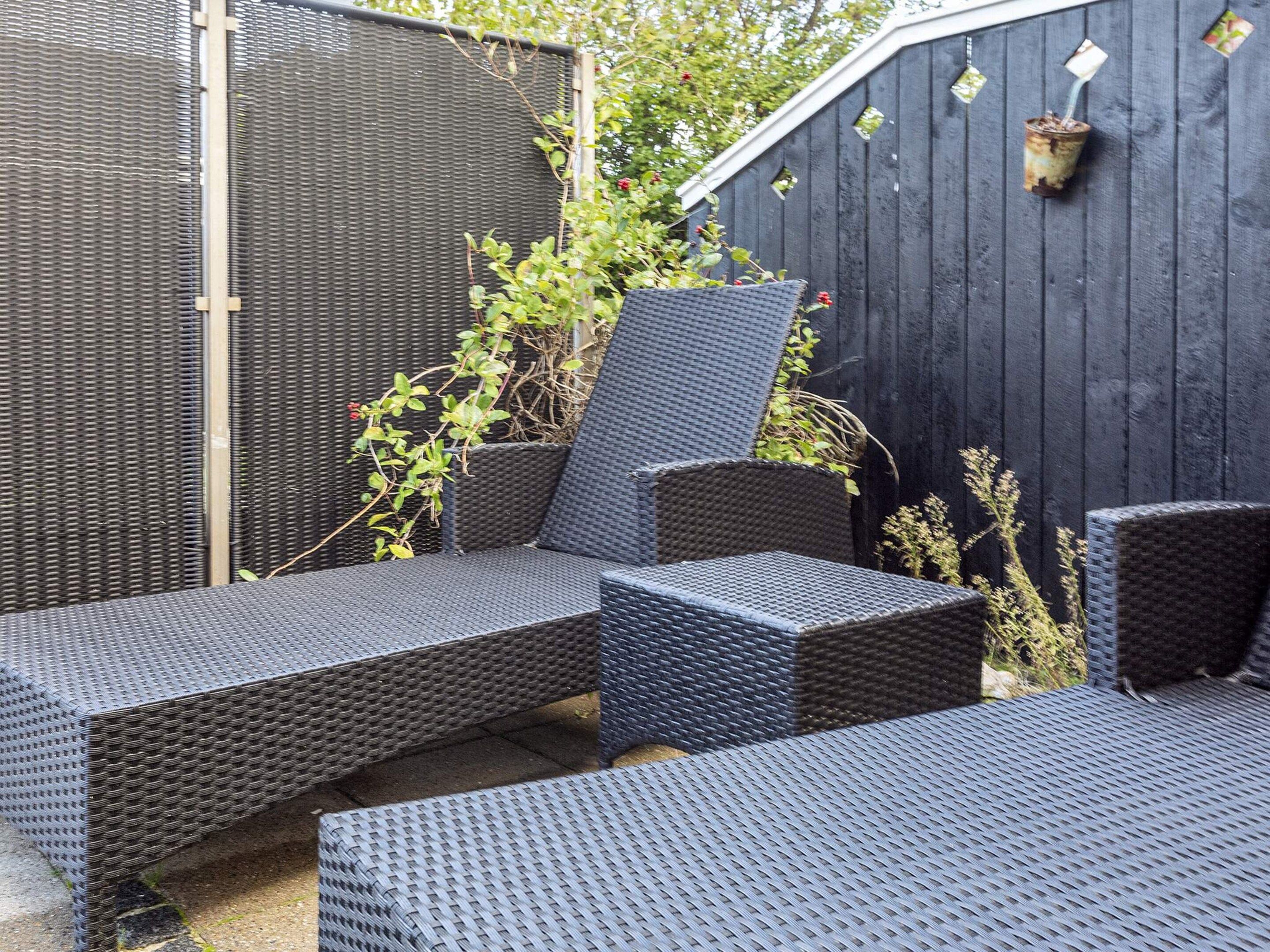 A patio area with wicker furniture, including a sofa and a chair.