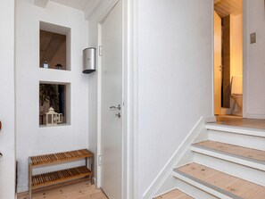 A staircase with wooden steps and white walls, leading to a room with a door. - 4 Star Holiday Home in Skagen (Skagen)