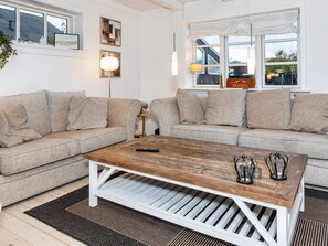 A living room with two sofas, a coffee table, and a lamp. - 4 Star Holiday Home in Skagen (Skagen)