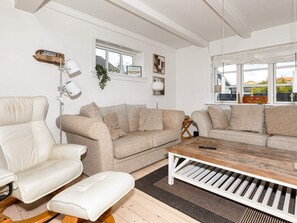 A living room with a white sofa, a beige sofa, a wooden coffee table, and a white armchair. - 4 Star Holiday Home in Skagen (Skagen)