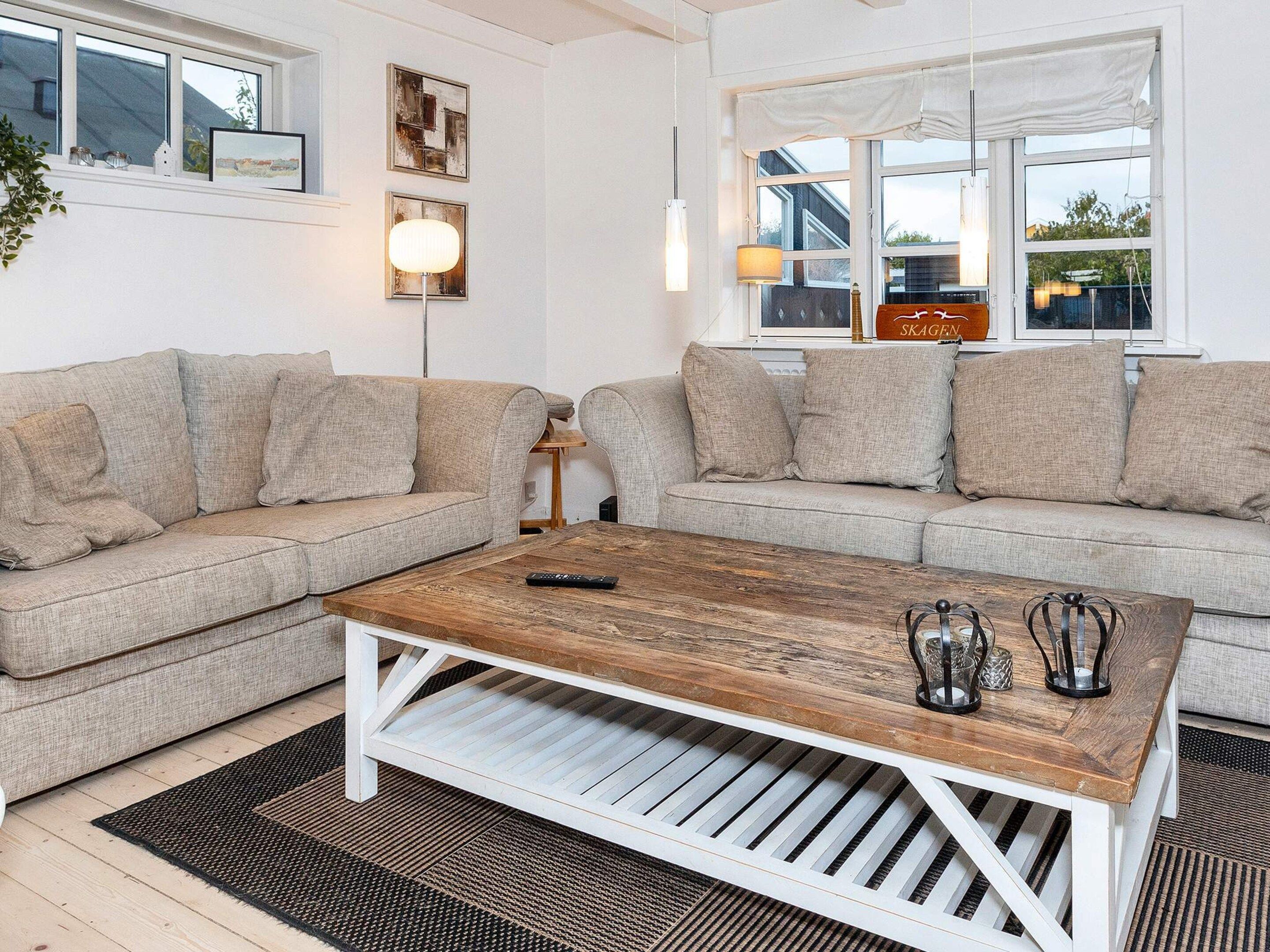 Een woonkamer met twee banken, een houten salontafel en een lamp.