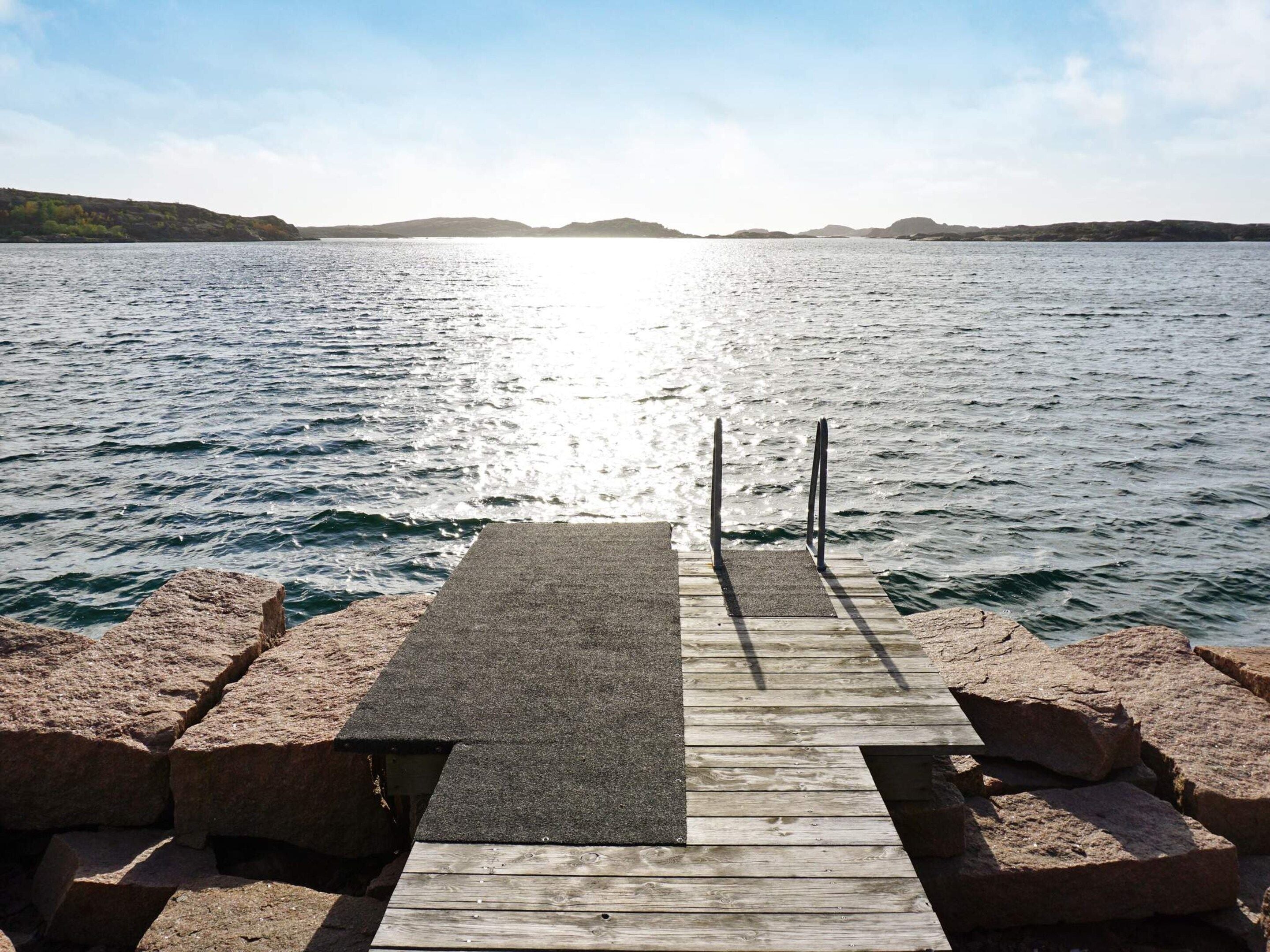 Un muelle de madera que se adentra en una masa de agua tranquila bajo un cielo despejado.