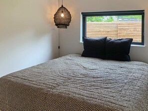A bedroom with a bed, a window, and a hanging light fixture. - 8 Person Holiday Home in Hornbaek-by Traum (Hornbaek)