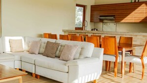 Ein modernes Wohnzimmer mit einem weißen Sofa, Holzstühlen und einem Wohnzimmerboden mit Fischgrätmuster.