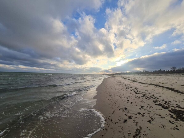 A beach with waves, a sandy shore, and a partly cloudy sky. - 4 Star Holiday Home in Vaeggerlose (Vaeggerlose)