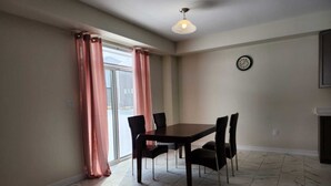 A dining area with a table and chairs, a clock on the wall, and a ceiling light. - Brand new home in Caledonia walking distance to river trail (Caledonia)