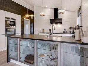 A modern kitchen with a central island, stainless steel appliances, and pendant lighting. - 5 Star Holiday Home in Hejls (Hejls)
