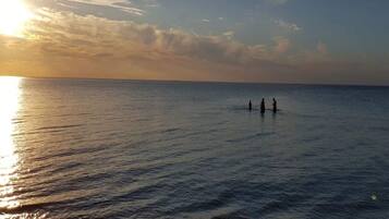 A beach scene with calm water and a sunset.