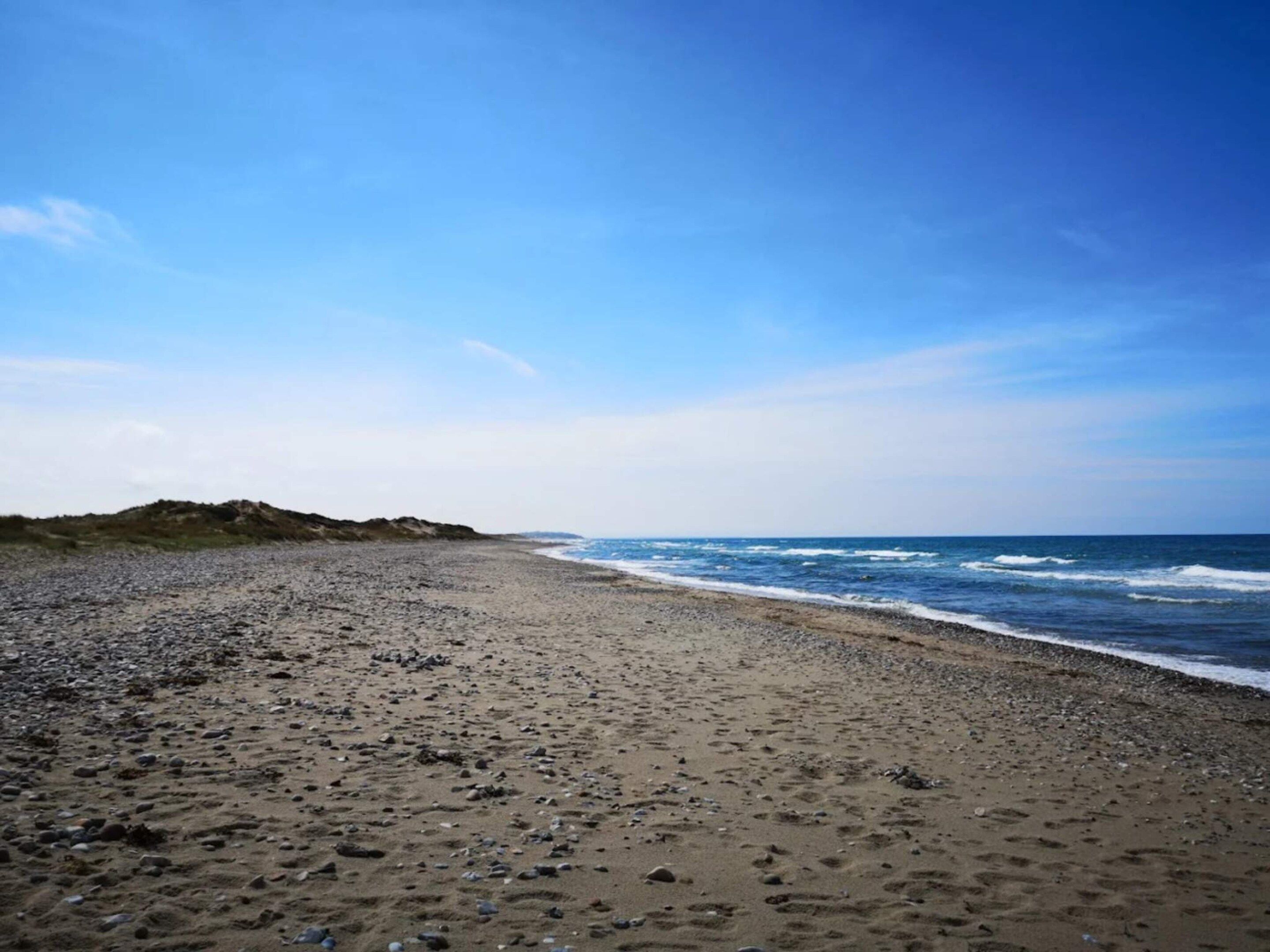 Ein Strand mit felsigem Ufer und Wellen.
