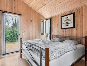 A bedroom with a bed, a window, and a door leading to an outdoor area. - 4 Star Holiday Home in Frederiksvaerk (Frederiksvaerk)